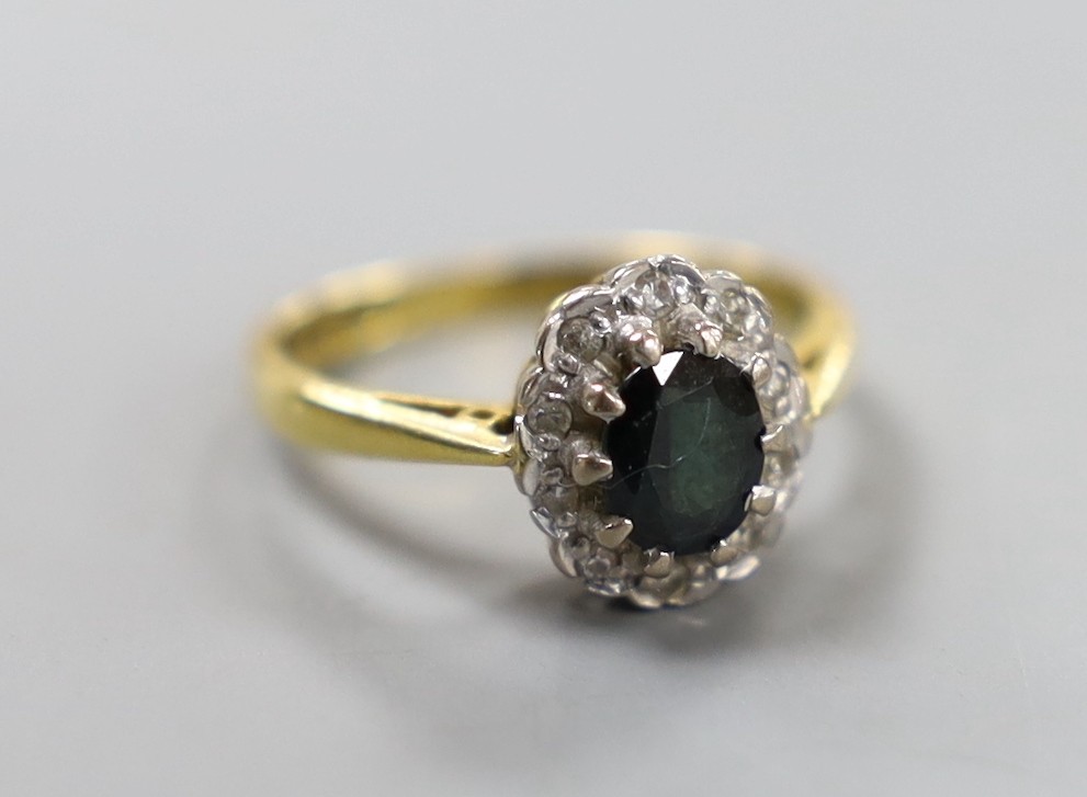 A modern 18ct gold, sapphire and diamond chip set oval cluster ring, size G, gross weight 3.1 grams.